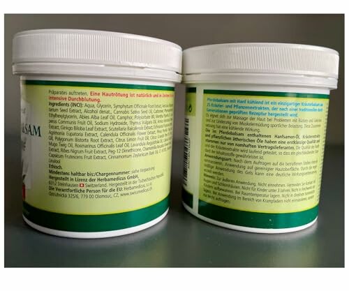 Zwei Dosen mit Kräuterbalsam auf einem Tisch.